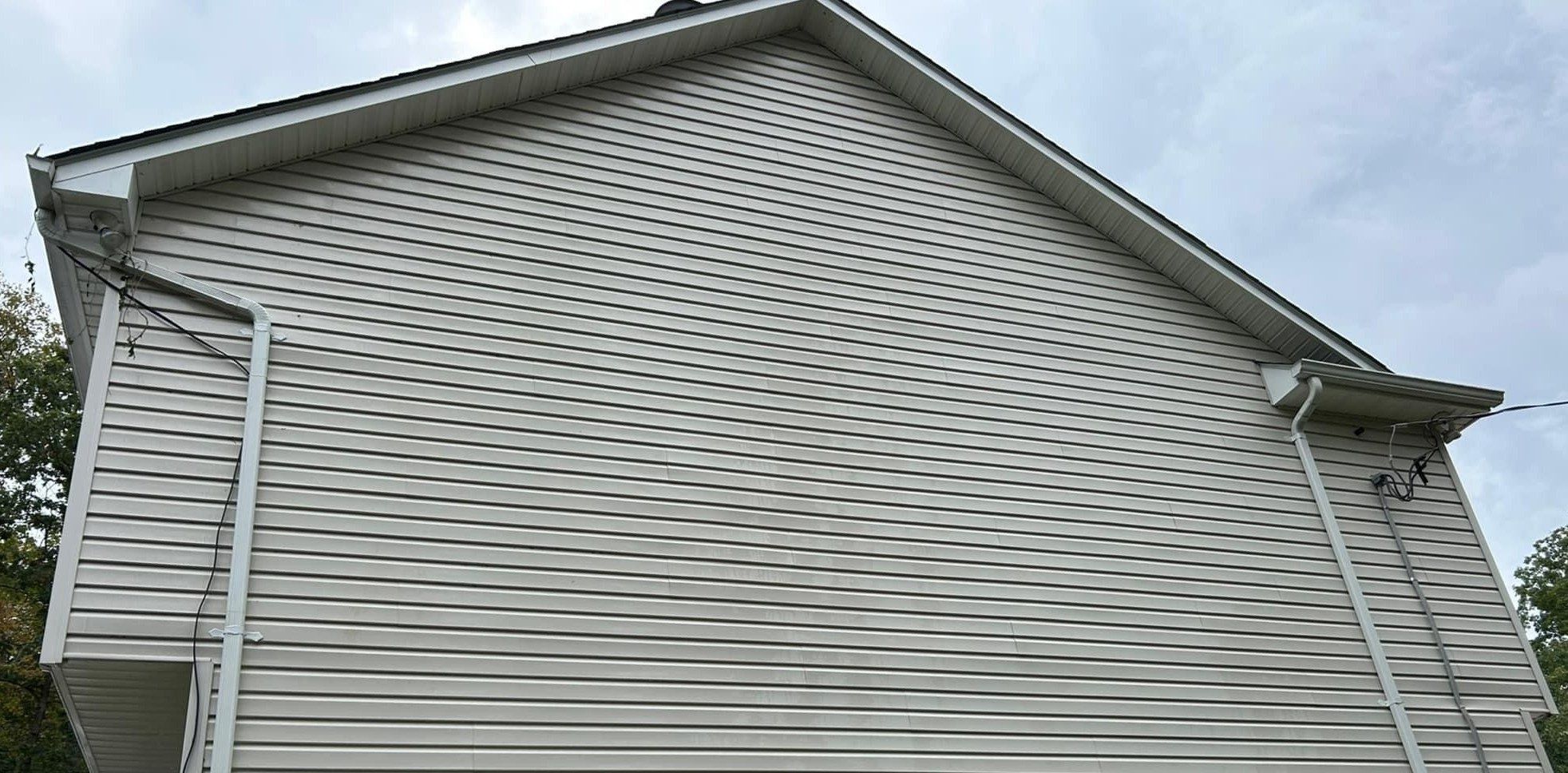 The same gray vinyl gable wall evenly clean after soft washing