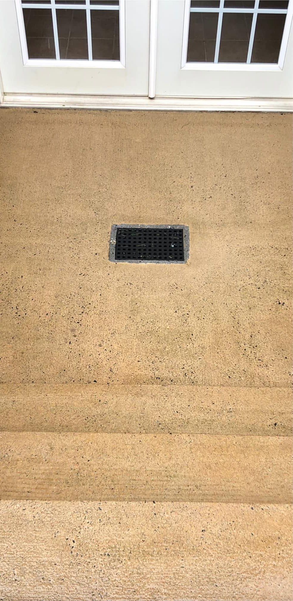 The same patio and steps after washing, even tan concrete around the drain