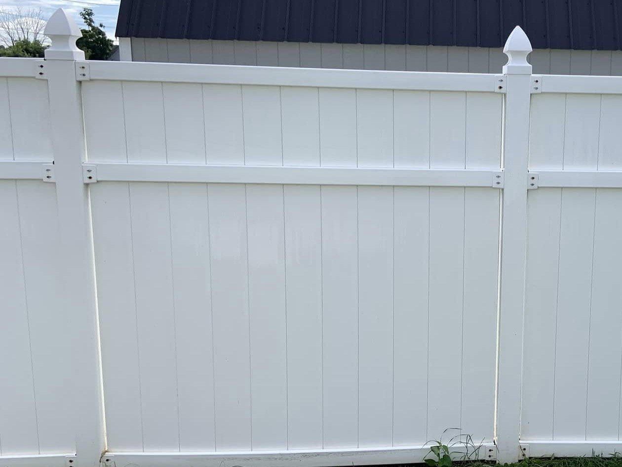 The same white vinyl fence panel clean and bright after washing