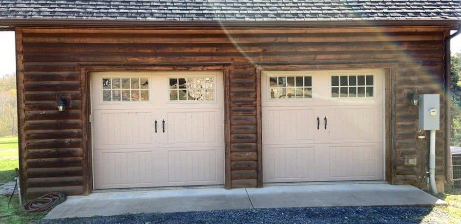 Two-door garage with dark, weathered log siding
