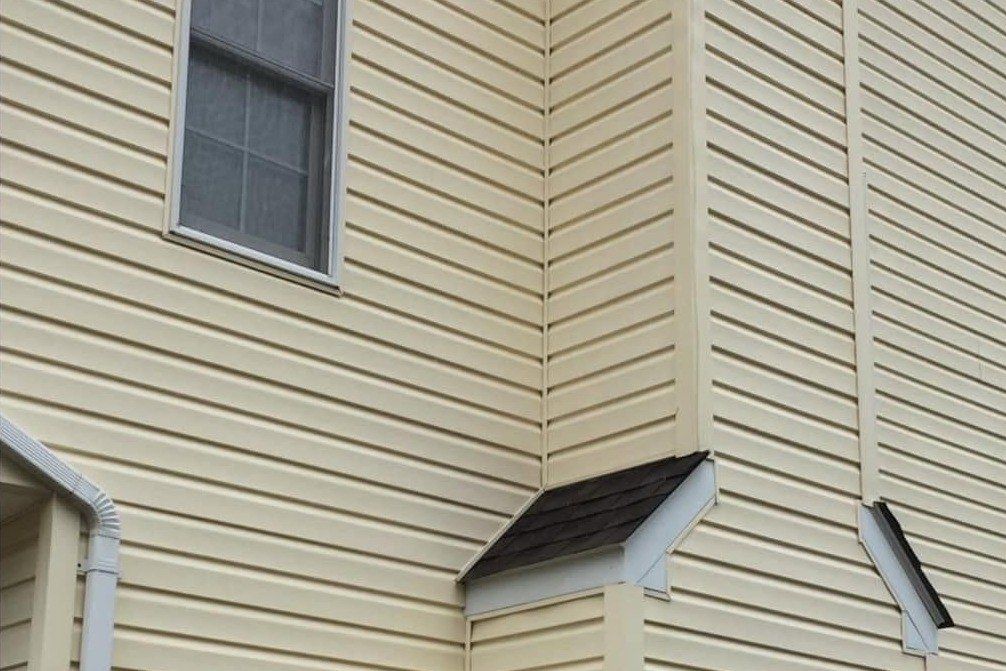 The same yellow siding and shed roof corner clean and even after a soft wash