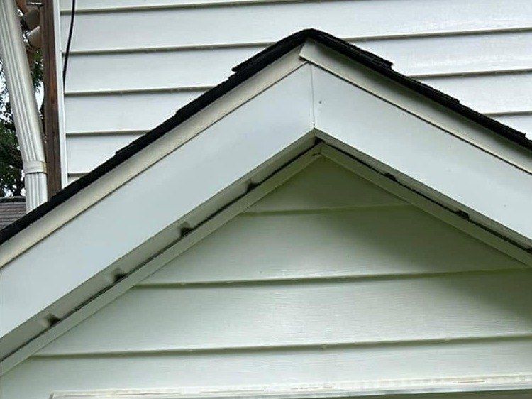 The same cellar entry gable after a soft wash, trim and siding bright white