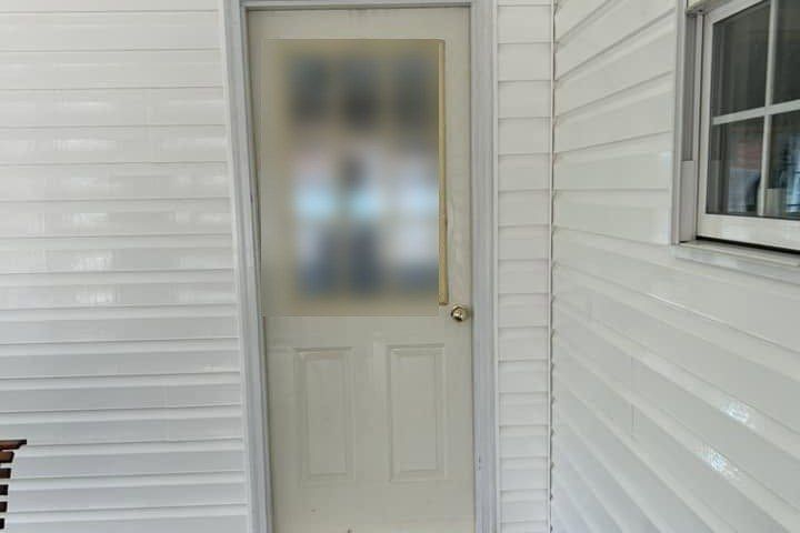 The same porch door and siding after washing, laps clean and the floor still wet