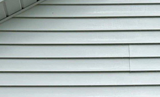 The same gable-wall siding under the soffit after a soft wash, clean and white