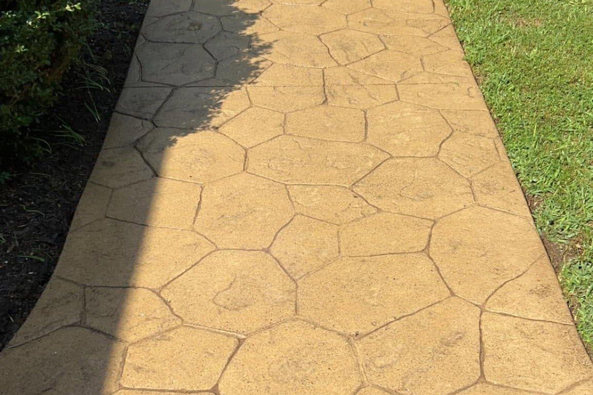 Stamped concrete walkway clean after pressure washing, stone pattern joints crisp