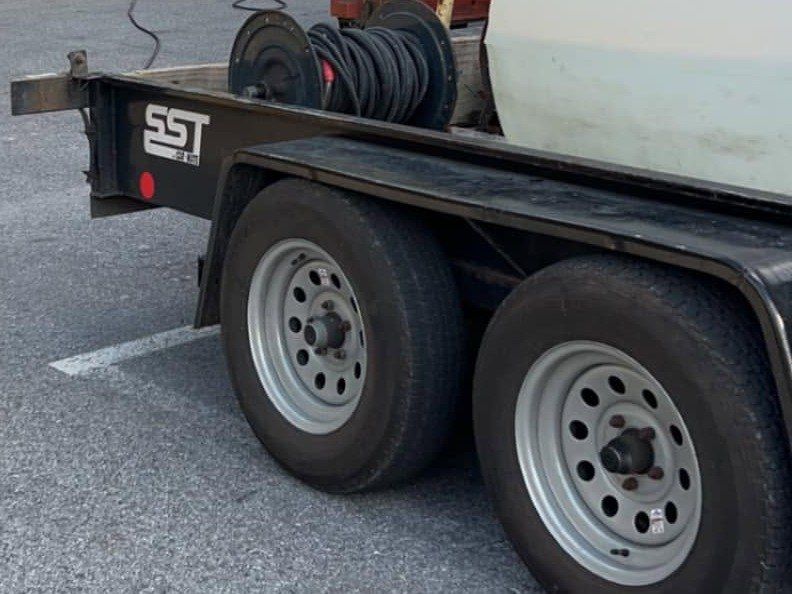 Trailer-mounted hose reel and water tank on a job site