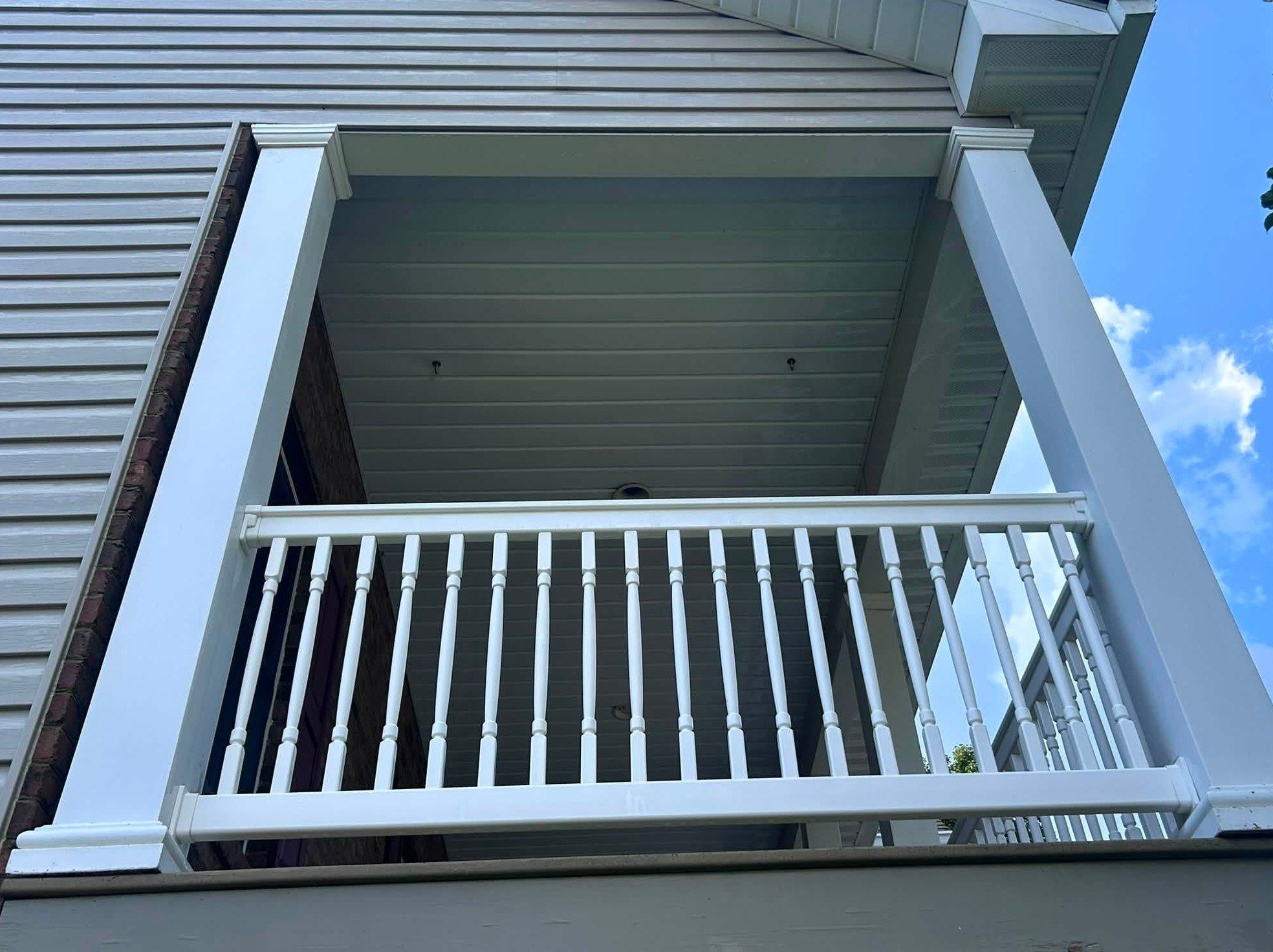 The same balcony after washing, bright white columns and railing