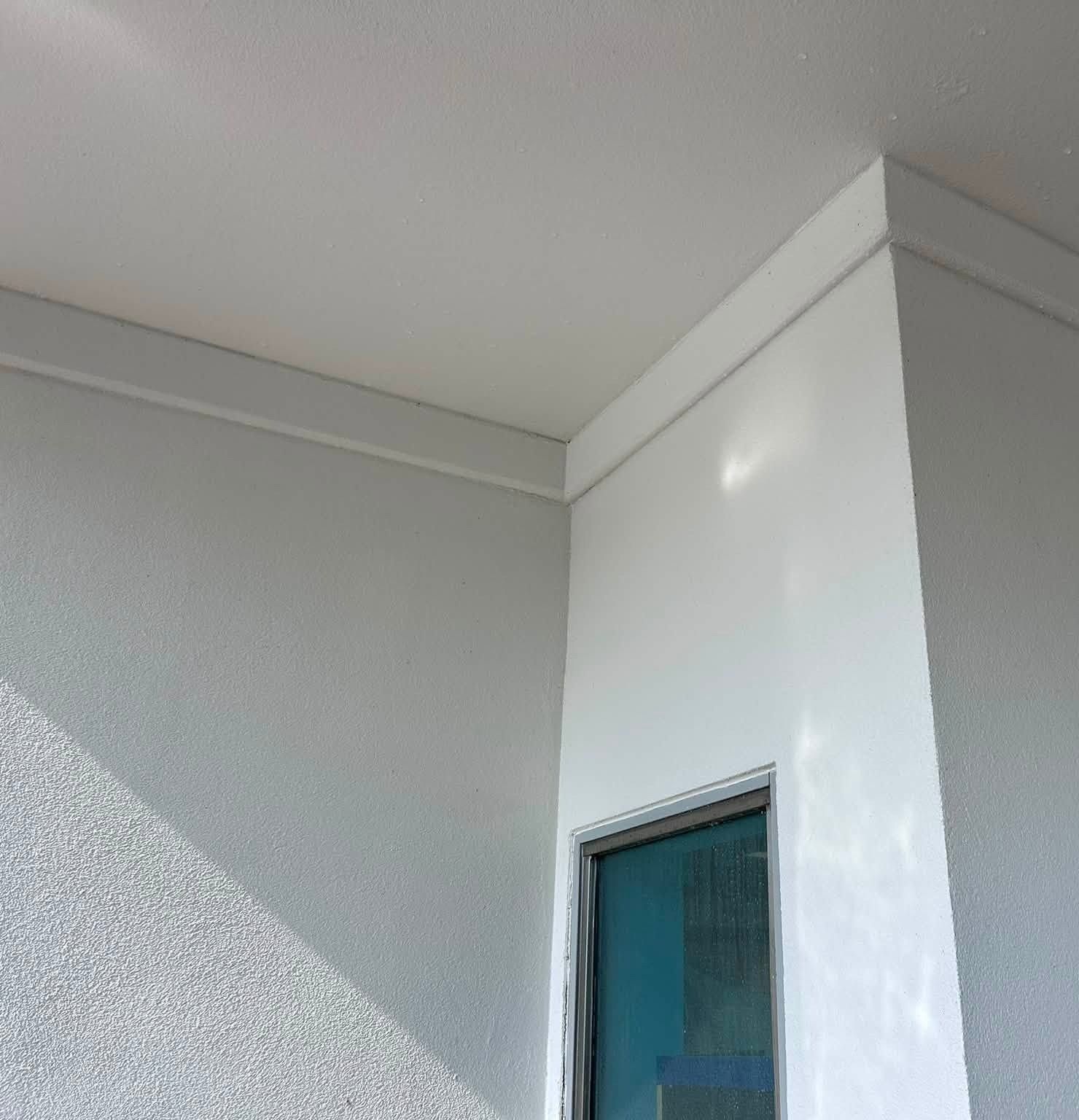The same stucco corner and soffit clean and bright after a commercial wash