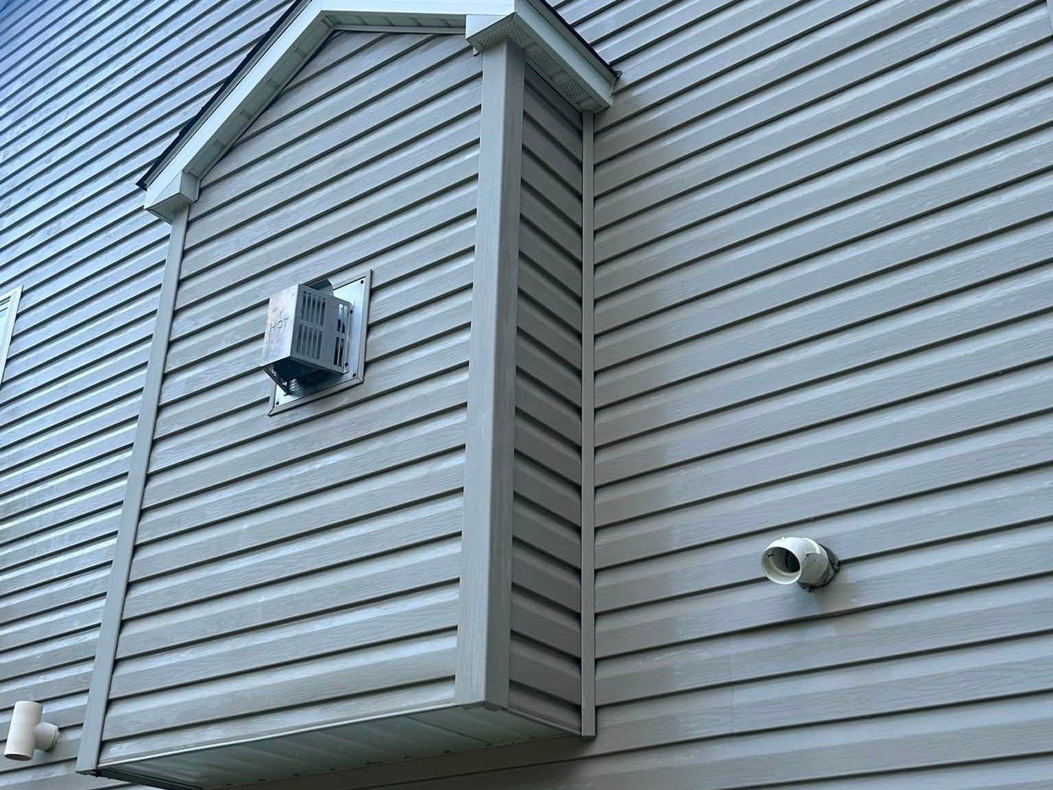 The same bump-out wall after a soft wash, algae gone and siding even in color