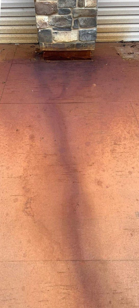 Painted floor with a dark rust streak running out from under a stone column