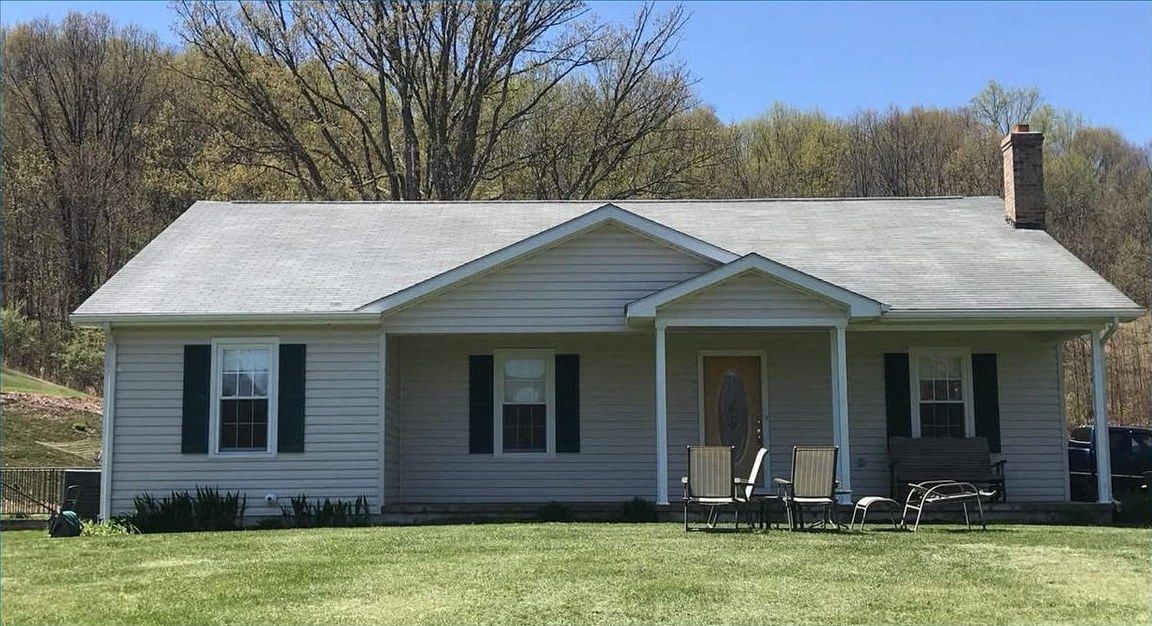 The same ranch house after the roof and siding were washed
